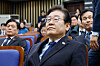 Democratic Party leader Lee Jae-myung watches news of President Yoon Suk Yeol's arrest by the Corruption Investigation Office for High-ranking Officials while attending an emergency general meeting of lawmakers held at the National Assembly in Yeouido, western Seoul, on Jan. 15. [NEWS1]