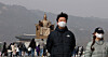 People wear masks and walk around Gwanghwamun Square in central Seoul as yellow dust sweeps the nation on Feb. 22. [YONHAP]