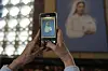 A person takes a picture of a paint of Blessed Maria Carmen Rendiles at the Belen's school church where her remains are interred in Caracas, Venezuela, on March 31. [AP/YONHAP]