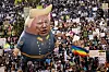 A large balloon with an image of US President Donald Trump is seen above protesters holding signs during the nationwide ″Hands Off!″ protest against Trump and his advisor, Tesla CEO Elon Musk, in downtown Los Angeles on April 5. Protesters flooded the streets of several major US cities on Saturday to oppose the divisive policies of President Donald Trump, in the largest demonstrations since his return to the White House. [AP/YONHAP]