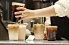 An employee at Starbucks makes coffee in a store in downtown Seoul on July 31. [NEWS1]