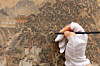 A conservator treats the 19th-century folding screen “Welcoming Banquet of the Governor of Pyongan.' [OVERSEAS KOREAN CULTURAL HERITAGE FOUNDATION]