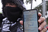 A migrant seeking asylum holds up the CBP One app showing his appointment was canceled after U.S. President Donald Trump was sworn into office on Jan. 20. [AP/YONHAP]