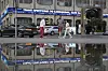 People cross a street as a news ticker installed on the facade of TASS news agency building reports on U.S. President Donald Trump threatening Russia with new tariffs, in Moscow, Russia, Monday, July 14, 2025. [AP/YONHAP]