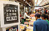 A sign reading “Consumer Coupons Accepted Here” is posted at a shop in Cheongnyangni Traditional Market in eastern Seoul on July 27. [YONHAP]