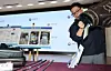 An official of the Seoul Customs Office demonstrates how a criminal group illegally transferred and smuggled 137 billion won ($94 million) in gambling funds between Korea and the Philippines using a golf bag on Aug. 21. [YONHAP]