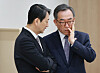 Foreign Minister Cho Tae-yul, right, speaks to Industry Minister Ahn Duk-guen at the Yongsan presidential office on Tuesday. [YONHAP]