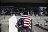 A protester draped in an American flag stands in front of the Federal Building in Los Angeles during a demonstration in response to a series of United States Immigration and Customs Enforcement raids throughout the country, on Tuesday, June 10, 2025. [AP/YONHAP]