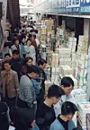 People flock to a used-book street along Cheonggyecheon in Seoul to buy secondhand textbooks for the new school year, filling the narrow alleys in January 2004. [JOONGANG ILBO]