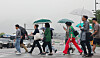 Pedestrians with umbrellas cross Sejong-daero, a street in Jongno District, central Seoul, on June 16 as rain pelts the country. [YONHAP]