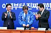 Democratic Party (DP) presidential candidate Lee Jae-myung, center, tries on a new party jacket during the DP Supreme Council meeting at the National Assembly in Yeouido, western Seoul, on April 28. [NEWS1]