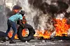 A man adds a tire to a burning barricade during a protest against insecurity, in the Petion-Ville neighborhood of Port-au-Prince, Haiti on April 2. [REUTERS/YONHAP]