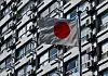 Air conditioner outdoor units are fixed on the outer wall of an apartment building while a Japanese national flag flutters in Tokyo, Japan, June 28, 2022. [REUTERS/YONHAP]
