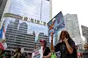 A demonstrator holds a sign in front of Trump International Hotel and Tower, as people gather for a ″No Kings″ protest against U.S. President Donald Trump's policies, in Chicago, Illinois, on Oct. 18. [REUTERS/YONHAP]