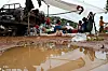 Displaced people sit among bags and supplies under a tarp at a pagoda in Oddar Meanchey, Cambodia.