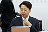 Reform Party leader Lee Jun-seok adjusts his tie ahead of a supreme council meeting at the National Assembly in western Seoul on Dec. 15. [YONHAP]