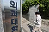 A student walks into the campus of a medical school in Seoul on April 16. [YONHAP]