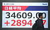 A man walks past an electronic board showing the closing numbers of the Nikkei Stock Average on the Tokyo Stock Exchange in Tokyo on April 10. [AFP/YONHAP]