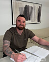Logan Allen signs his contract with the NC Dinos in a photo sahred by the club on Dec. 18. [SCREEN CAPTURE]