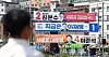 A passerby walks by banners of presidential cadidates ? Democratic Party's Lee Jae-myung, People Power Party's Kim Moon-soo and Reform Party's Lee Jun-seok ? in downtown Seoul on May 12. [NEWS1]