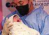 The father of this year’s first newborn holds the baby at Gangnam CHA hospital in Gangnam District, southern Seoul, at midnight of this year’s very first day, Jan. 1. Although the baby was born in 2024, it is not a child of the Blue Dragon because the lunar year starts in February. [NEWS1]