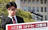 Former conservative People Power Party (PPP) leader Han Dong-hoon props up his glasses while announcing his bid for the presidential race in front of the National Assembly in Yeouido, western Seoul, on April 10. [YONHAP]