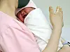 A newborn is seen in the arms of a nurse at a hospital in Guro District, western Seoul on May 28. [NEWS1]