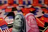 A U.S. dollar banknote featuring U.S. founding father Benjamin Franklin and China's yuan banknote featuring late Chinese chairman Mao Zedong are seen among U.S. and Chinese flags [REUTERS/YONHAP]