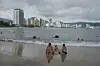 Tourists sit on the shore before the arrival of Hurricane Erick, in Acapulco, Mexico, June 18. [AP/YONHAP]
