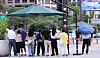 Citizens wait under a canopy at a crosswalk in central Seoul on Aug. 21, as sweltering heat continues. [NEWS1]