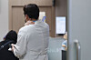A doctor massages his shoulder as he stands at a university hospital in Seoul on Friday. The government on the same day raised its national health crisis warning to the highest ″serious″ level as mass resignations of trainee doctors continued. [YONHAP]