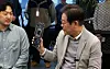 Democratic Party presidential candidate Lee Jae-myung holds a neural processing unit during his visit to local fabless startup FuriosaAI in southern Seoul on April 14. [JOINT PRESS CORPS]