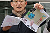 A member of a civic group protesting Coupang's security practices tear up posters that resemble 5,000-won ($3) coupons during a news conference titled “Declaration rejecting Coupang vouchers and Coupang withdrawals that deceive the public” in front of Coupang’s headquarters in Songpa District, southern Seoul, on Jan. 14. [YONHAP]