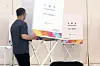 An official at a community welfare center in Buk District, Gwangju installs a voting booth ahead of early voting on May 27. [YONHAP]