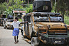 A man walks past an armored vehicle used by Kenyan police that, according to police at the site, were burned during an attack by armed gangs in the Kenscoff neighborhood of Port-au-Prince, Haiti, Aug. 14. [AP/YONHAP]
