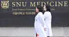Doctors walk across the Seoul National University College of Medicine campus in Jongno District, central Seoul, on March 27.[NEWS1]