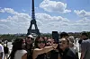 Tourists pose for a selfie with the Eiffel Tower in background on July 6, 2023 in Paris. [AP/YONHAP]