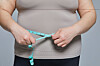 A person measures their waist in this image unrelated to the story. [GETTY IMAGES BANK]