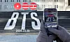 A pedestrian takes a photo of a promotional sign for BTS's fifth full-length album set to release in March, at Jongno District, central Seoul, on Jan. 22. [NEWS1]