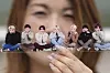 A fan of BTS poses with a group photo of the band during the annual 2025 BTS Festa celebrating the BTS' debut anniversary in Goyang, Gyeonggi, on June 13, 2025. [AP/YONHAP]