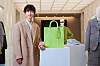 Actor Song Joong-ki poses wearing a coat and stands next to a bag from Louis Vuitton's new 2025 Spring/Summer collection line, inspired by the late dansaekhwa, or Korean monochrome painting, master Park Seo-bo. [LOUIS VUITTON]