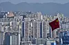 A Chinese national flag flutters against the high-rise residential buildings in Wushan county, in southwest China's Chongqing Municipality on May 21. [AP/YONHAP]