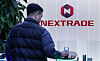 An individual passes by a Nextrade logo on March 3. [NEWS1]