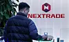 An individual passes by a Nextrade logo on March 3. [NEWS1]