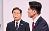 Democratic Party presidential candidate Lee Jae-myung, left, listens as People Power Party presidential candidate Kim Moon-soo speaks during the first presidential election debate at the SBS Sangam-dong studio in Mapo District, western Seoul, on May 18. [JOINT PRESS CORPS]