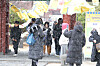 People walk in the snow falling by the Jeju-mok Government Office on Jeju Island, as an event welcoming Ipchun, the onset of spring, takes place on Feb. 3. [YONHAP]