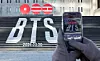 A pedestrian takes a photo of a promotional sign for BTS's fifth full-length album, set to release in March, at Jongno District, central Seoul, on Jan. 22. [NEWS1]