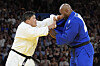 Korea's Kim Min-jong, left, and France's Teddy Riner compete in the men's 100-kilogram gold medal match at the Champ-de-Mars Arena in Paris on Friday.  [AP/YONHAP]