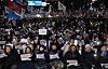 People brave the cold to hold a rally in front of the National Assembly in Yeouido, western Seoul, on Dec. 3, 2025 to mark the first anniversary of martial law imposition. The protesters held placards call for social reform and reckoning over the martial law fiasco, while others lit up the night with K-pop light sticks. [JOINT PRESS CORPS]