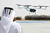 A man wearing traditional Emirati clothes films an experimental Joby Dubai Aerial Taxi aircraft taking off in Dubai, United Arab Emirates, June 30, 2025. [REUTERS/YONHAP]